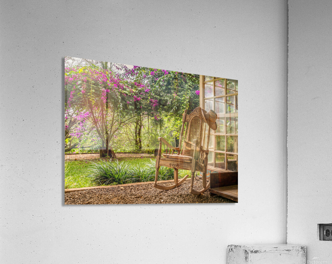 A vintage wooden rocking chair with a straw hat rests on a porch Acrylic Print