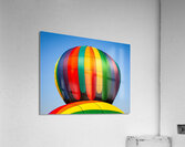 Colorful hot air balloon rising above another with blue sky  Acrylic Print