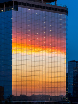 Brilliant sunset reflected in the glass of new office building