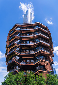 Reflective surface of the Vessel with a skyscraper behind with c