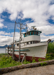 Historic but rotting fishing boat by ocean at Icy Strait Point