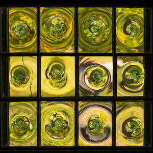 Window of old crown glass panes reflected garden