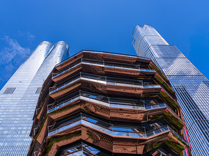 Reflective surface of the Vessel with a skyscraper behind with c