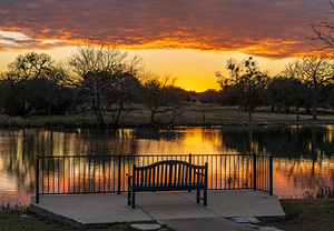Dramatic sunset over Legacy Hills Park lake and golf course near