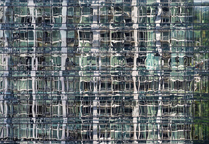 Reflections of condominium tower in windows of apartment buildin