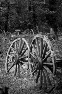 Two old wooden cartwheels against wood cart