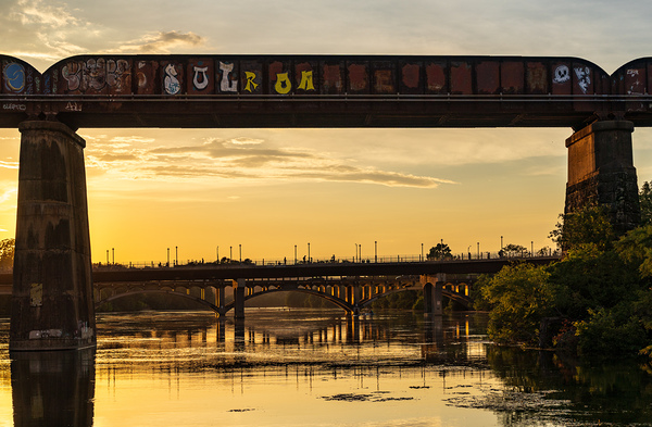 Bridges behind the railroad bridge in Austin at sunset Print