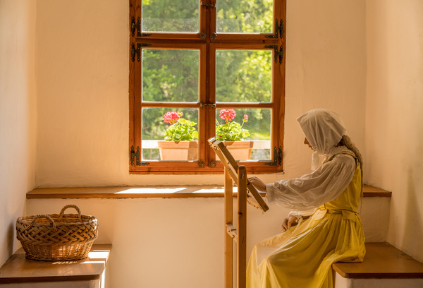 Woman working on embroidery in window alcove by Steve Heap