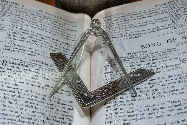 Silver square and compass on Bible for Freemasons by Steve Heap