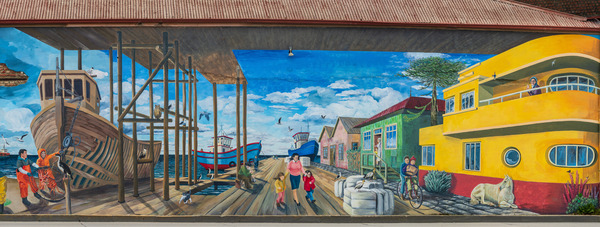 Wall mural of busy port on building in Punta Arenas in Chile by Steve Heap