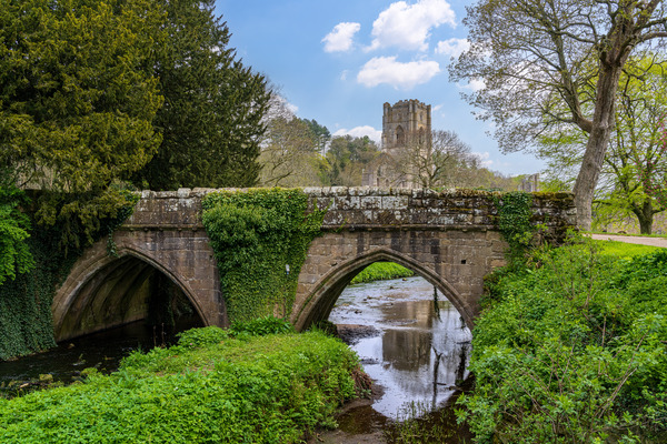 Stone bridge at Fountains Abbey ruins in Yorkshire England by Steve Heap