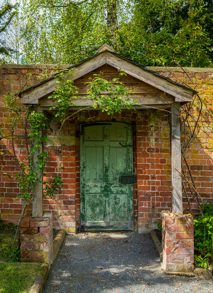 Painted green door and porch in walled garden wall by Steve Heap