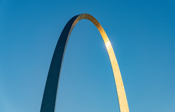 Unusual view of Gateway Arch at sunrise against blue sky by Steve Heap