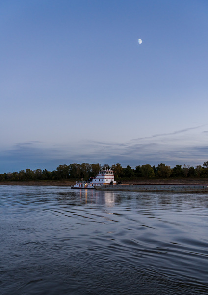 Freight barges on Mississippi river at dusk with moon by Steve Heap