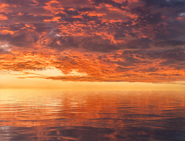 Dramatic sunset reflected in the smooth ripples of a lake or oce Print