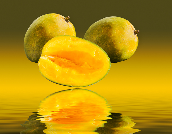 Two mangoes and one cut mango reflecting by Steve Heap