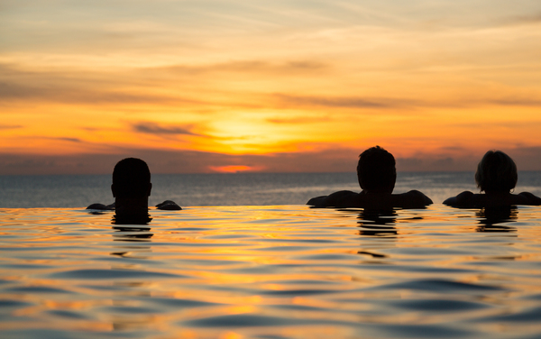 Silhouetted heads against infinity edge pool by Steve Heap