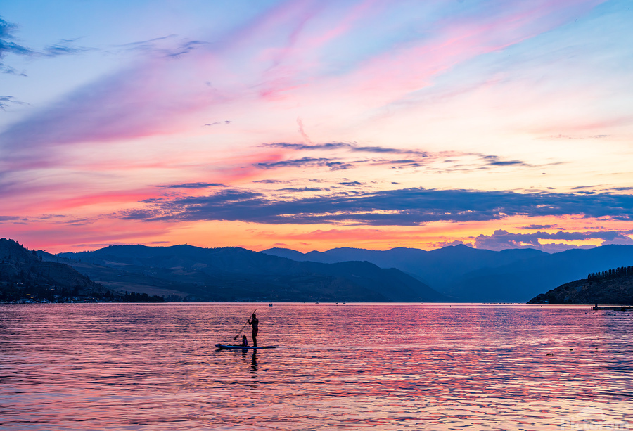 Sunset over Lake Chelan with silhouette of couple paddling on pa  Print