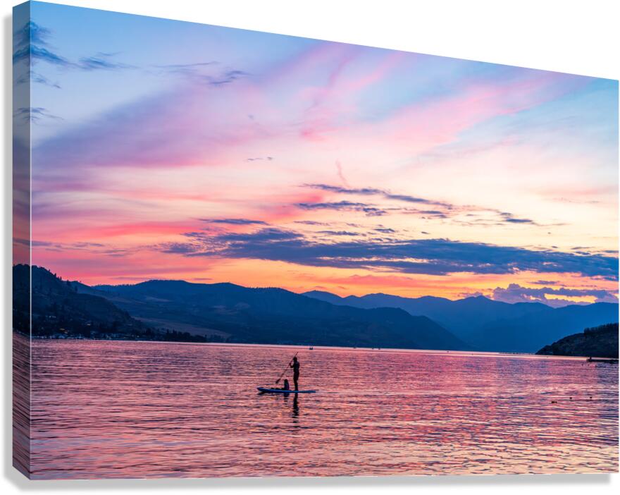 Sunset over Lake Chelan with silhouette of couple paddling on pa Canvas Print