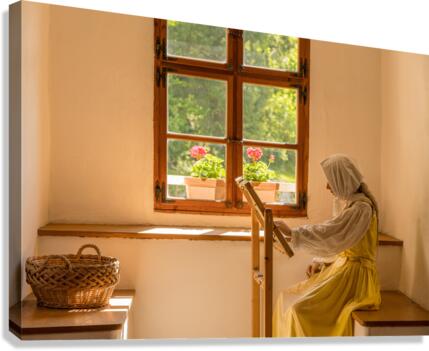 Woman working on embroidery in window alcove  Canvas Print