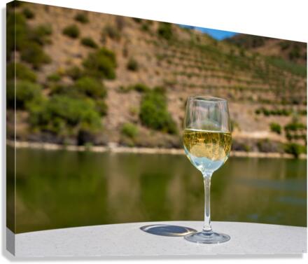 Glass of white wine by Douro river in Portugal  Canvas Print
