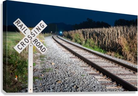 Oncoming train with railroad crossing sign  Canvas Print