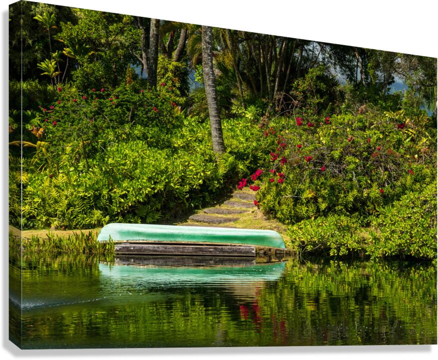 Green canoe on dock reflecting into calm lake or pond in garden  Canvas Print