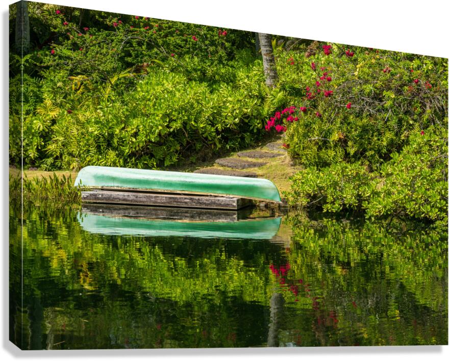 Green canoe on dock reflecting into calm lake or pond in garden  Canvas Print