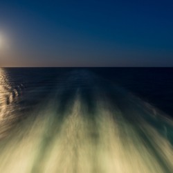 Moon over the wake of cruise ship travelling at speed
