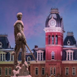 Mountaineer statue against Woodburn Hall tower