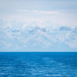 High mountains around Yakutat in mist as ship sails from Hubbard