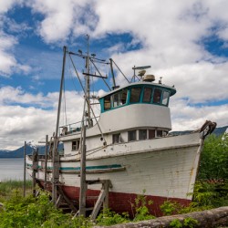 Historic but rotting fishing boat by ocean at Icy Strait Point