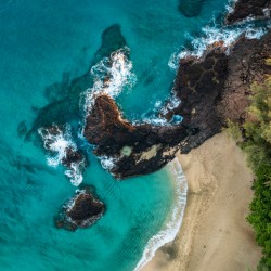 Top down view of rocks and waves on Lumahai beach Kauai
