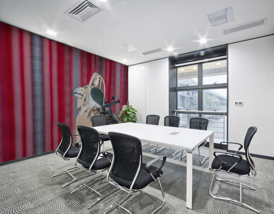 Falcon indoors wearing a leather cap with straps around its neck Wall Printing