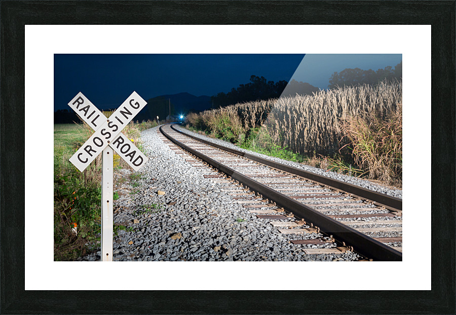Oncoming train with railroad crossing sign Picture Frame print
