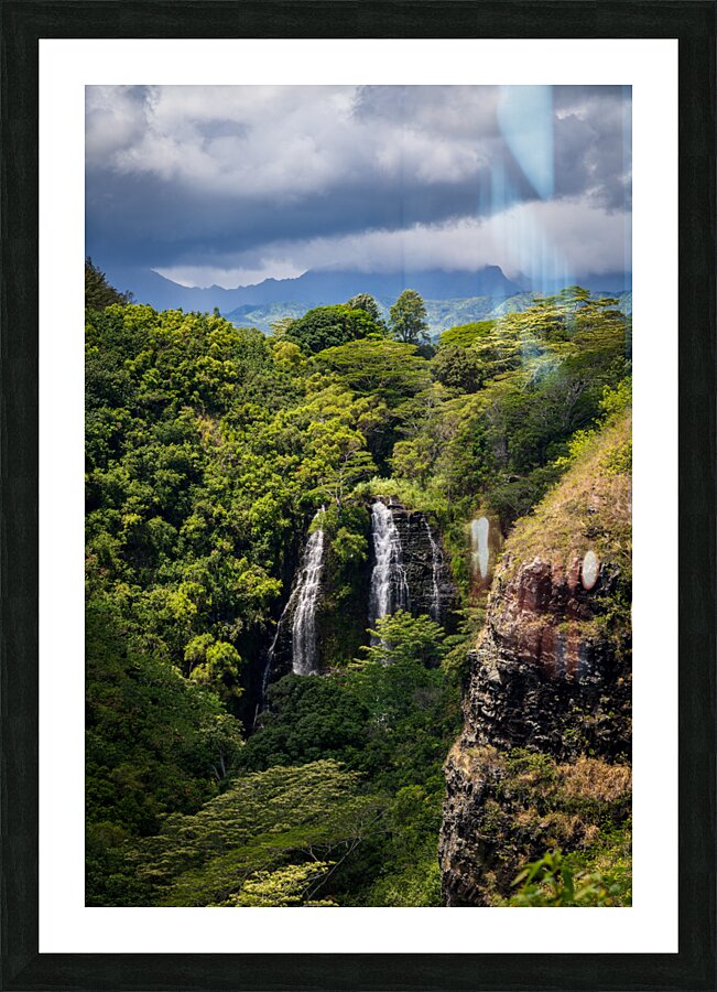 Opaekaa Falls sunlit as dark storm clouds gather over the hills Picture Frame print