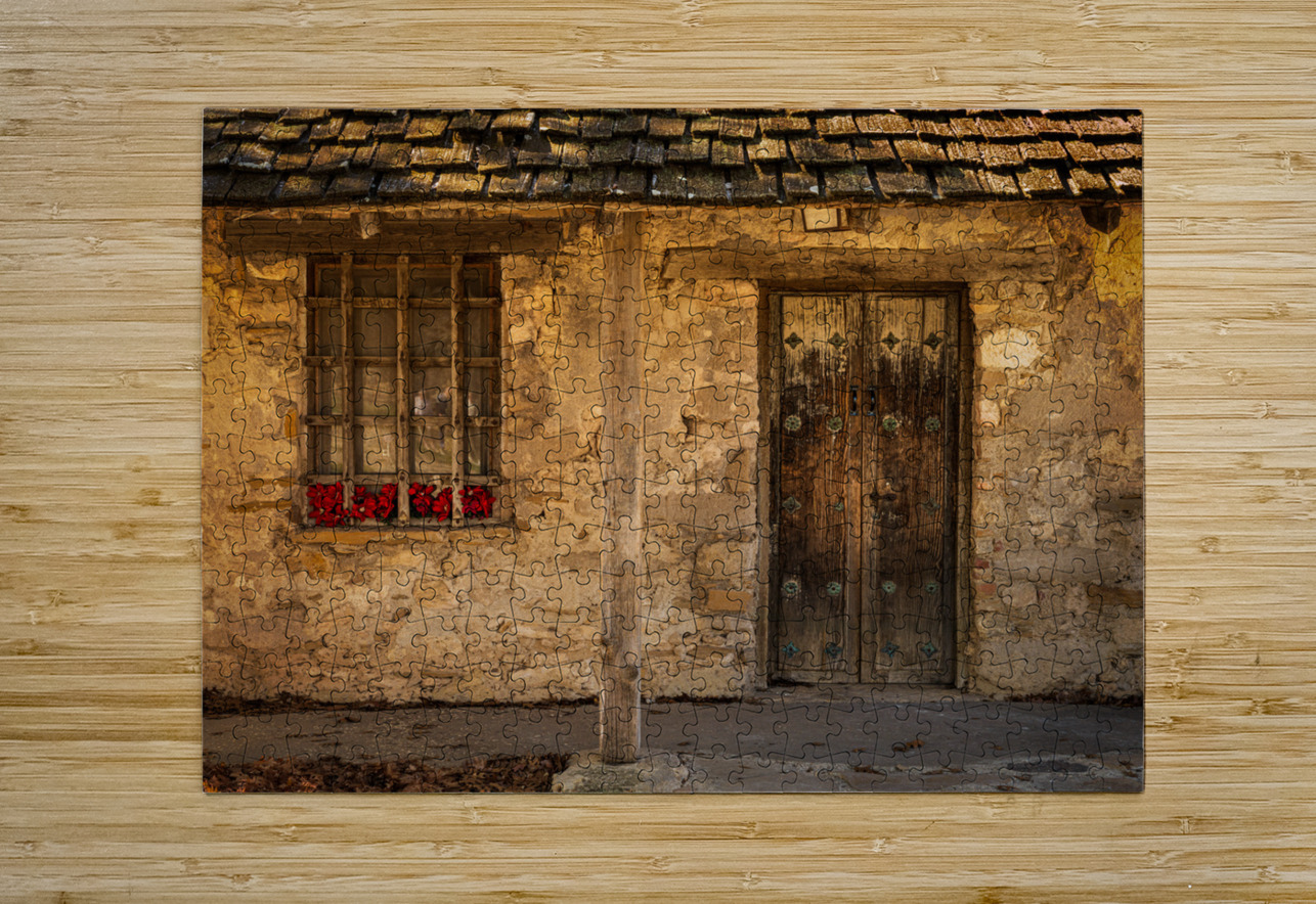 Rustic San Juan building with a barred window red flowers and a Steve Heap Puzzle printing