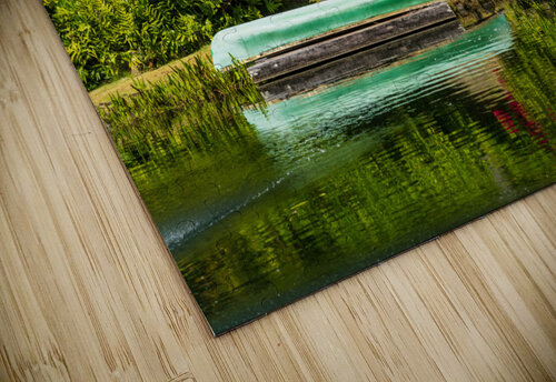 Green canoe on dock reflecting into calm lake or pond in garden Steve Heap puzzle