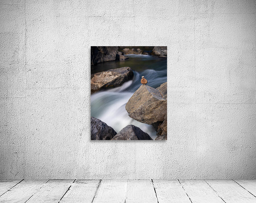Pebbles balanced on rocks in raging river illustrating resilienc Wall Preview