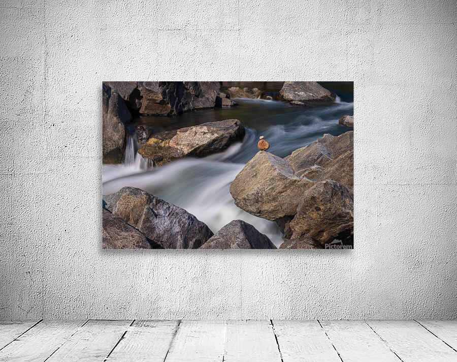 Pebbles balanced on rocks in raging river illustrating resilienc Wall Preview