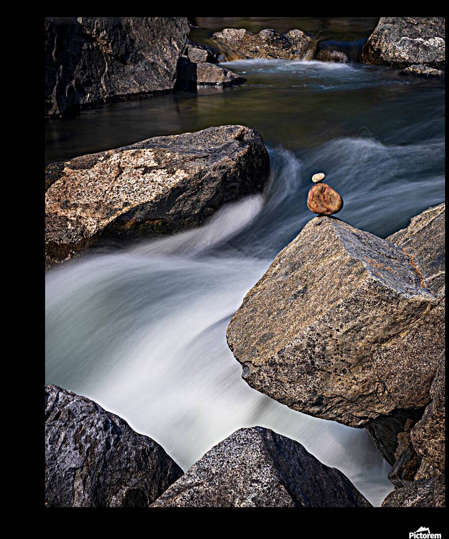 Pebbles balanced on rocks in raging river illustrating resilienc Reproduction