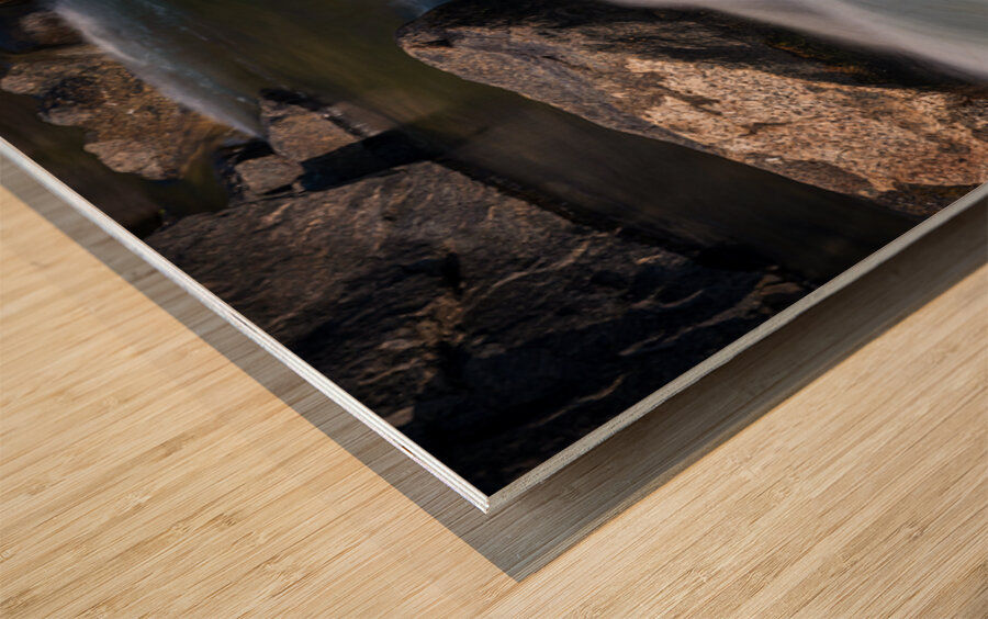 Pebbles balanced on rocks in raging river illustrating resilienc Wood print